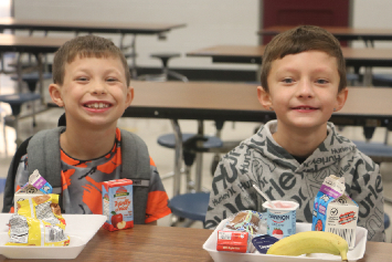 Two students at H.H. Beam Elementary sit together enjoying a nutritious breakfast before the school 