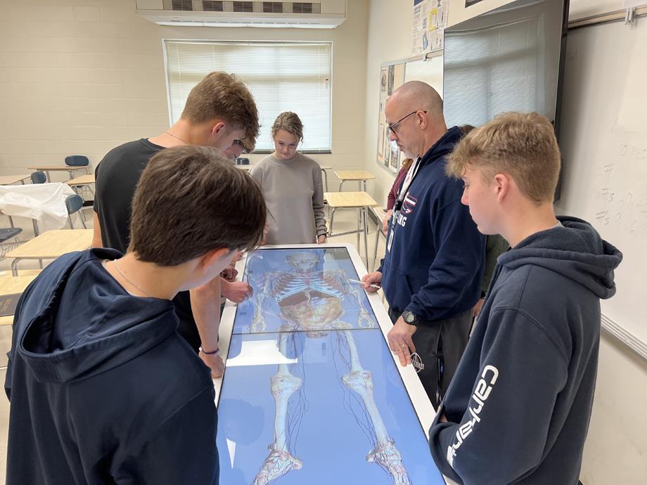 Teacher Nikki Akins reviews a lesson with students on the Anatomage Table.