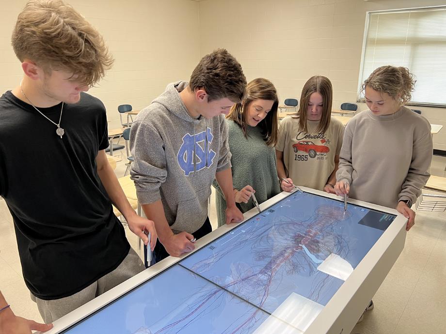 Teacher Nikki Akins reviews a lesson with students on the Anatomage Table.